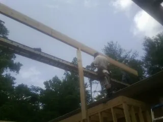 Carpenter setting a ridge beam over a new addition frame — Ice Dam Removal by Roofing Brothers in Herriman