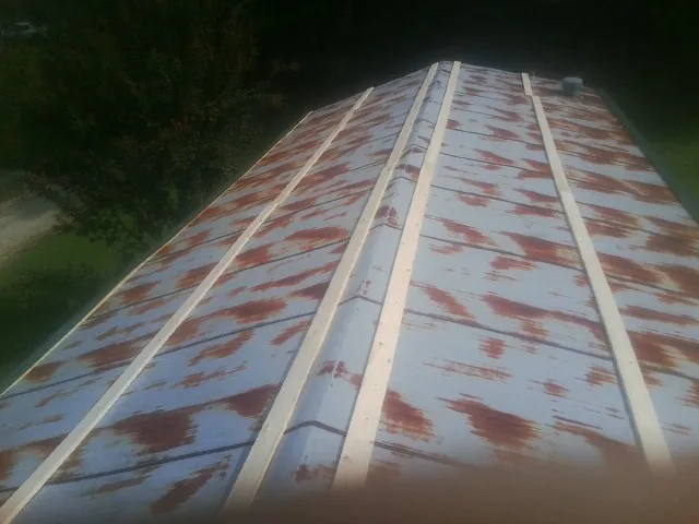 Rusted metal roof panels with new wood purlins before replacement — Storm Damage Roof Repair in Herriman by Roofing Brothers