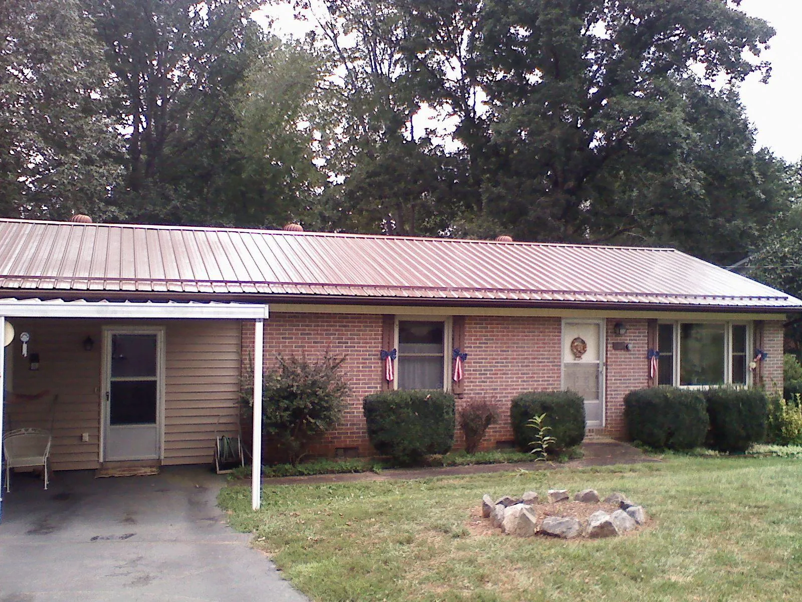 Bronze metal roof and carport on a brick ranch home — Roof Repair work by our crew in Herriman